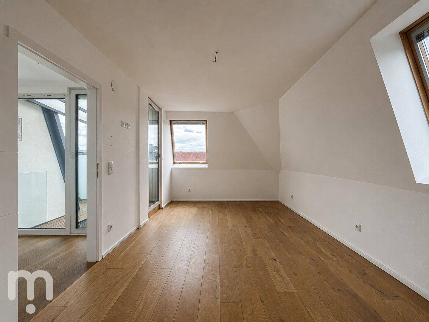 Geräumiges Dachgeschosszimmer mit Holzboden und mehreren Fenstern für viel Licht.
