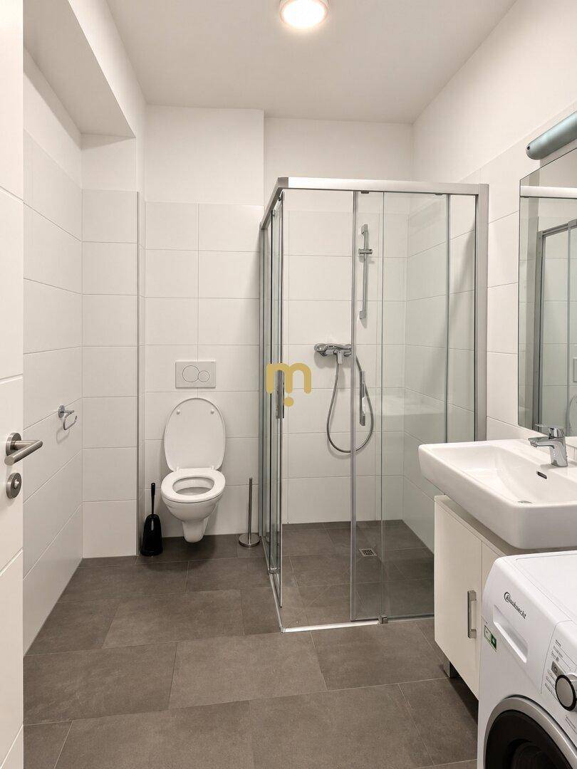 Modernes Badezimmer mit Duschkabine, Toilette, Waschbecken und grauen Bodenfliesen.