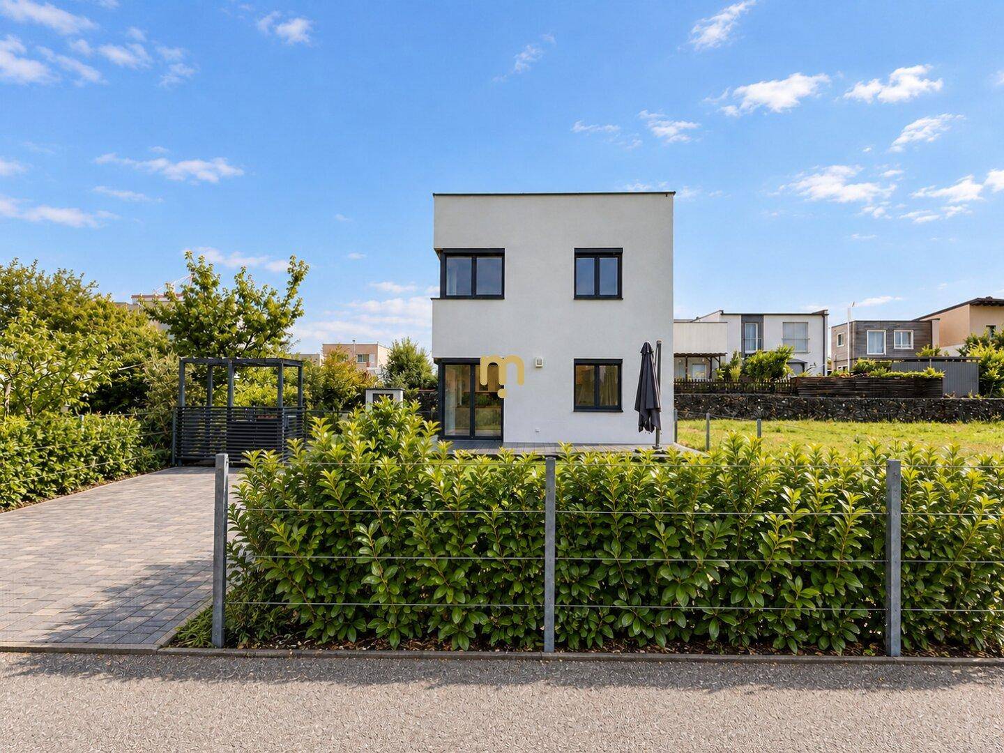 Rückansicht des modernen Hauses mit Rasenfläche und Blick auf die Nachbarschaft.