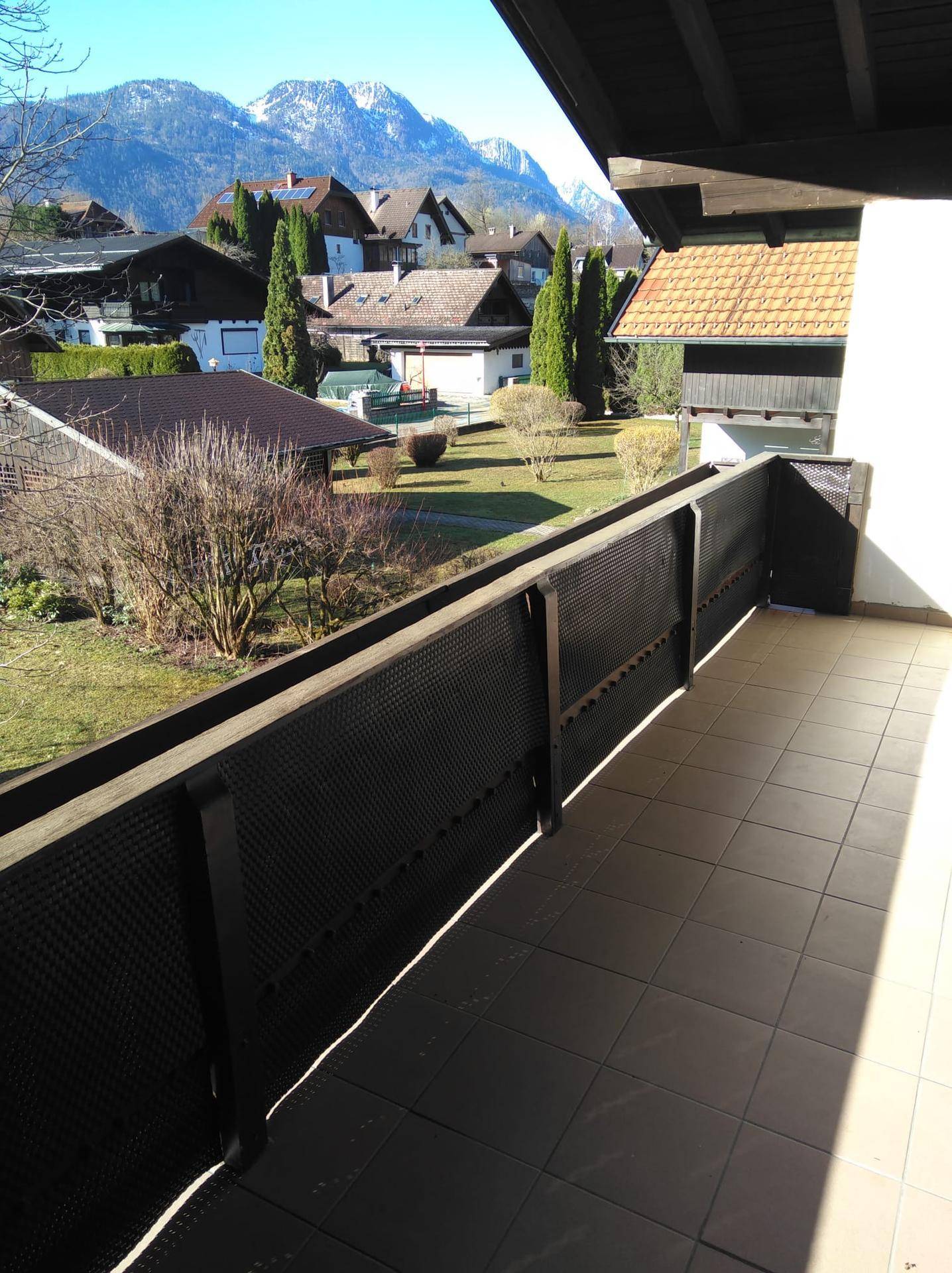 Geräumiger Balkon mit Fliesenboden und weitem Blick auf die umliegende Berglandschaft.