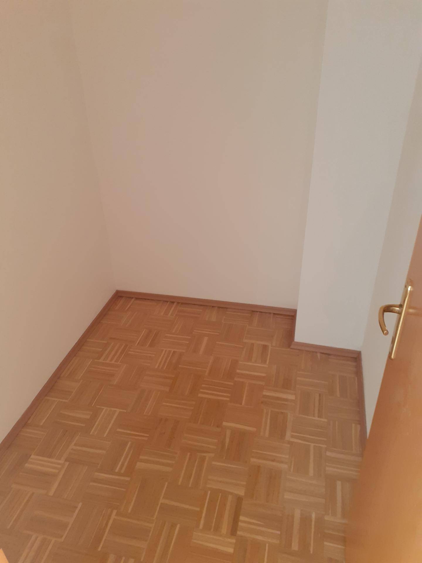 Kleines, helles Zimmer mit Parkettboden und weiß gestrichenen Wänden, vielseitig nutzbar.