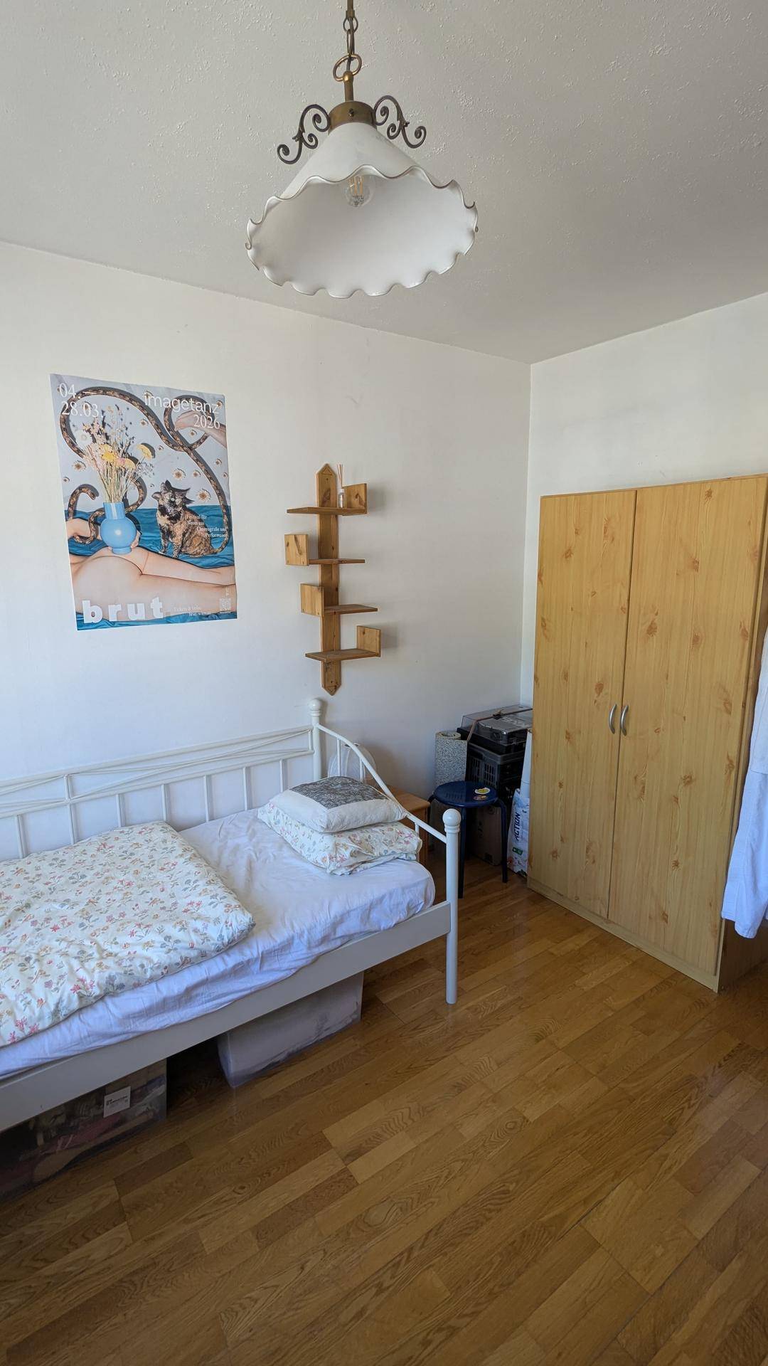 Helles Schlafzimmer mit Einzelbett, Holzschrank und Parkettboden, ideal für Gäste oder Kinder.