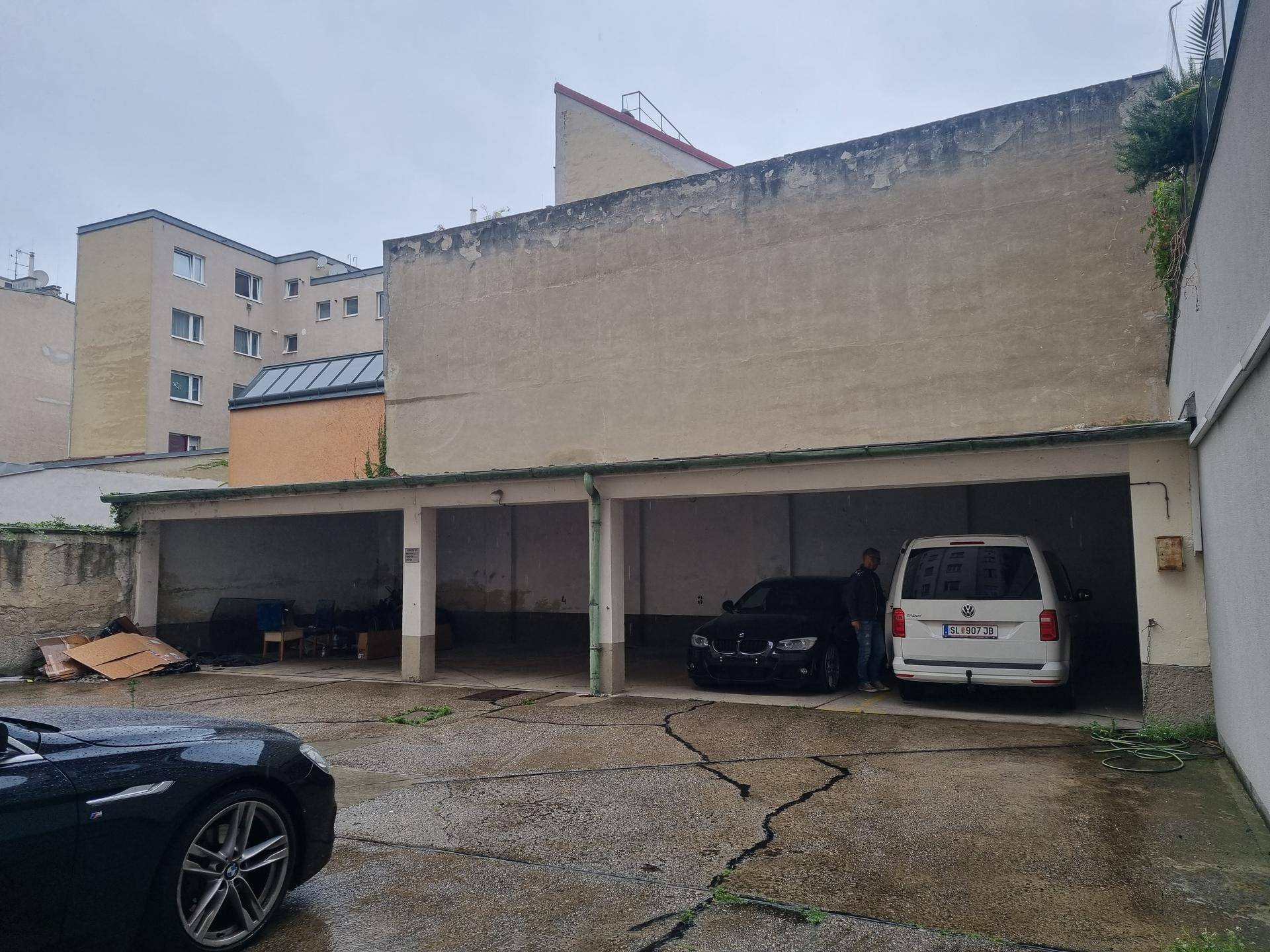 Hinterhofbereich mit mehreren offenen Garagenstellplätzen und angrenzenden Wohngebäuden.