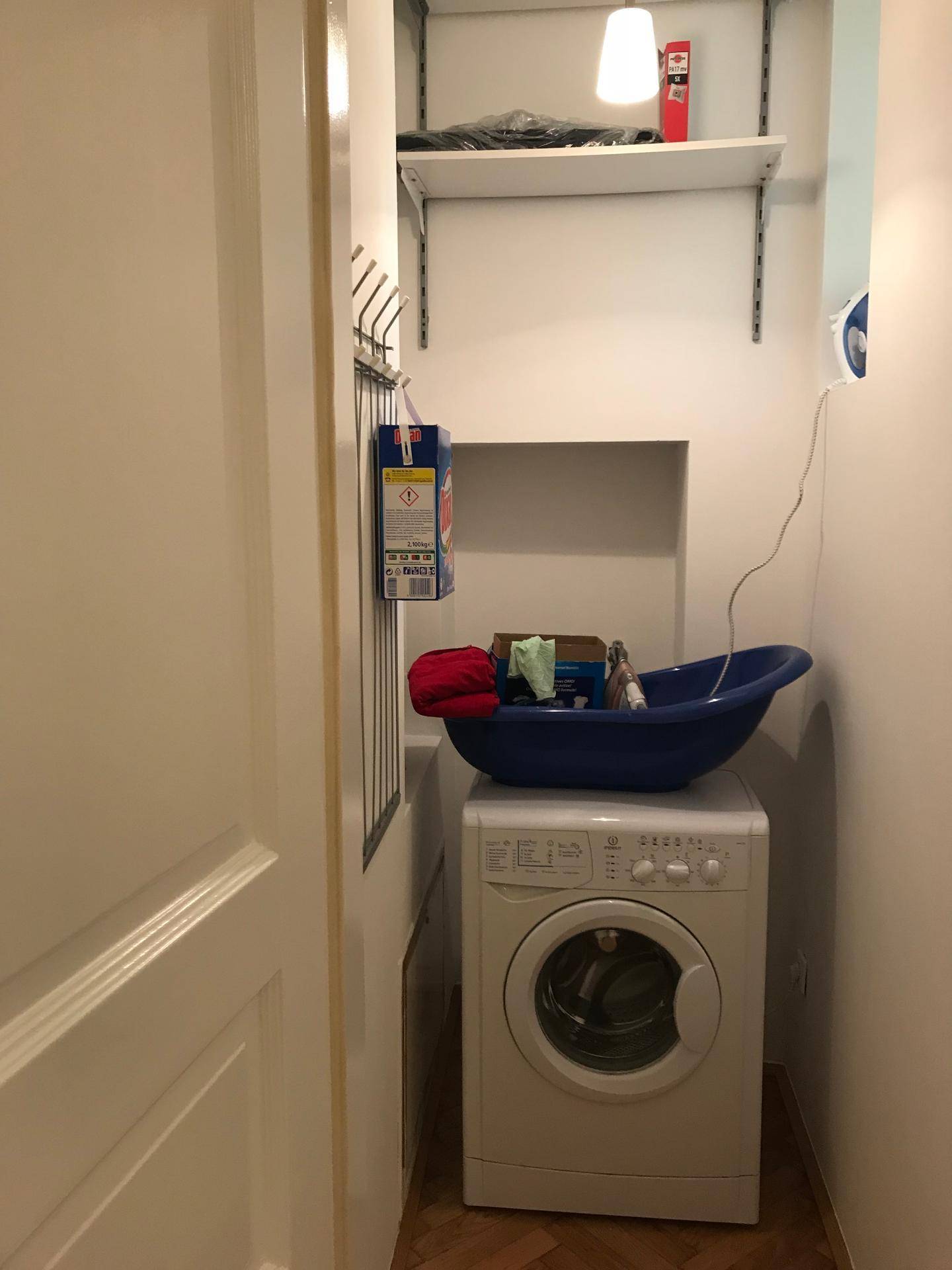 Praktischer Hauswirtschaftsraum mit Waschmaschine und Ablageregalen.