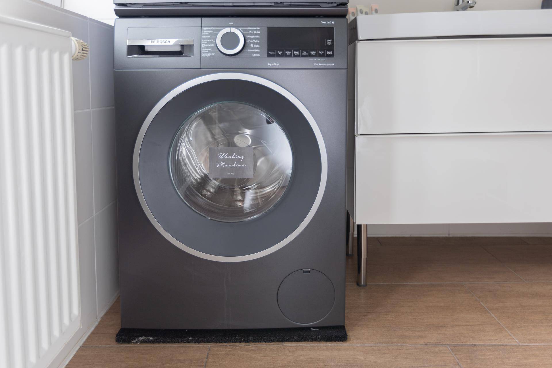 Moderne Waschmaschine von Bosch in einem hellen Raum mit Fliesenboden.