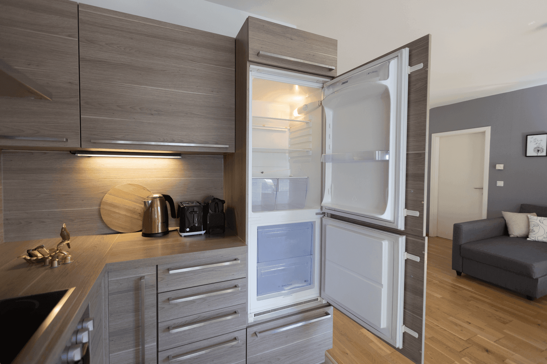 Offener Kühlschrank in einer modernen Küche mit holzfarbenen Schränken.