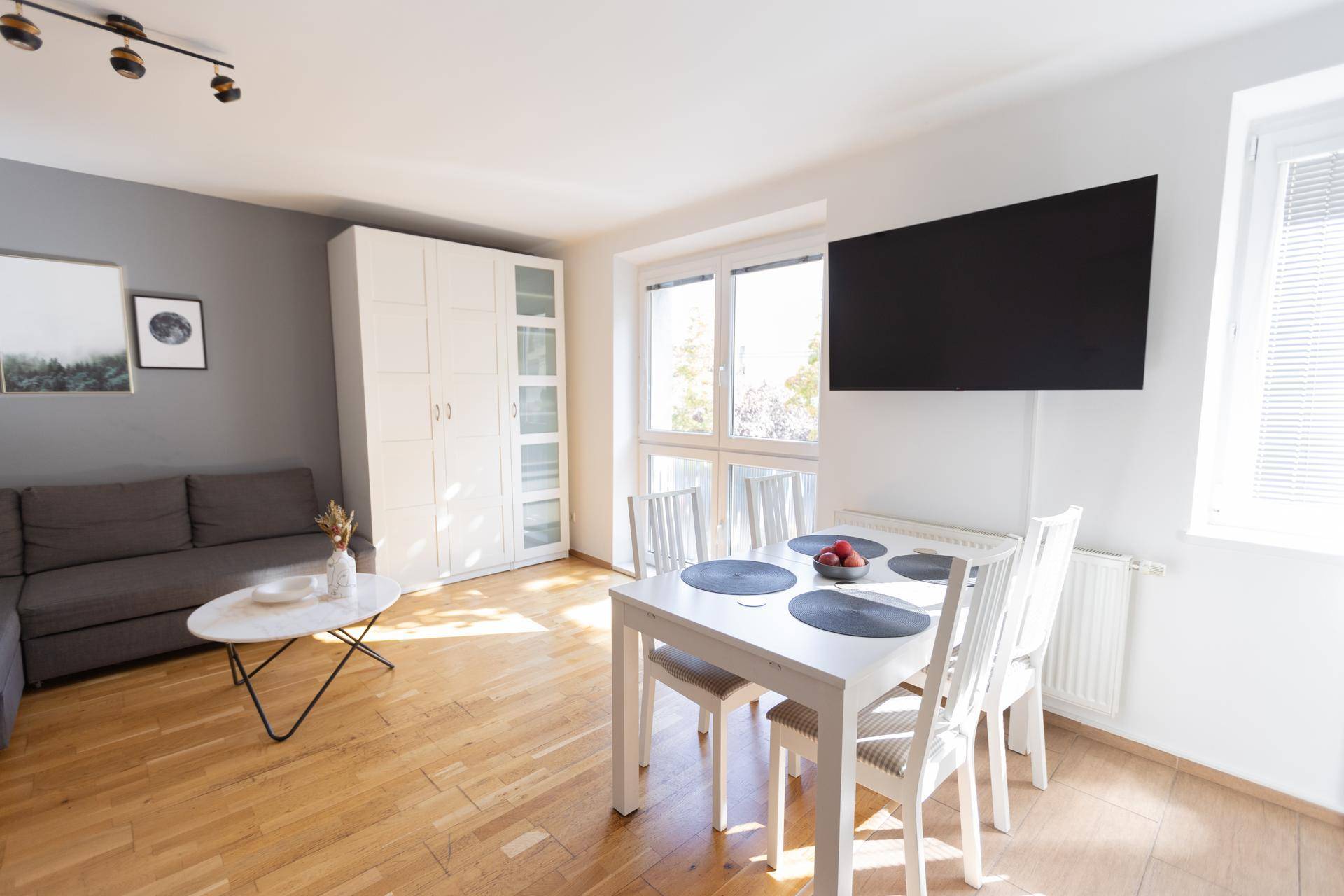 Lichtdurchfluteter Wohn-Essbereich mit Esstisch, Sofa und großem Fenster.