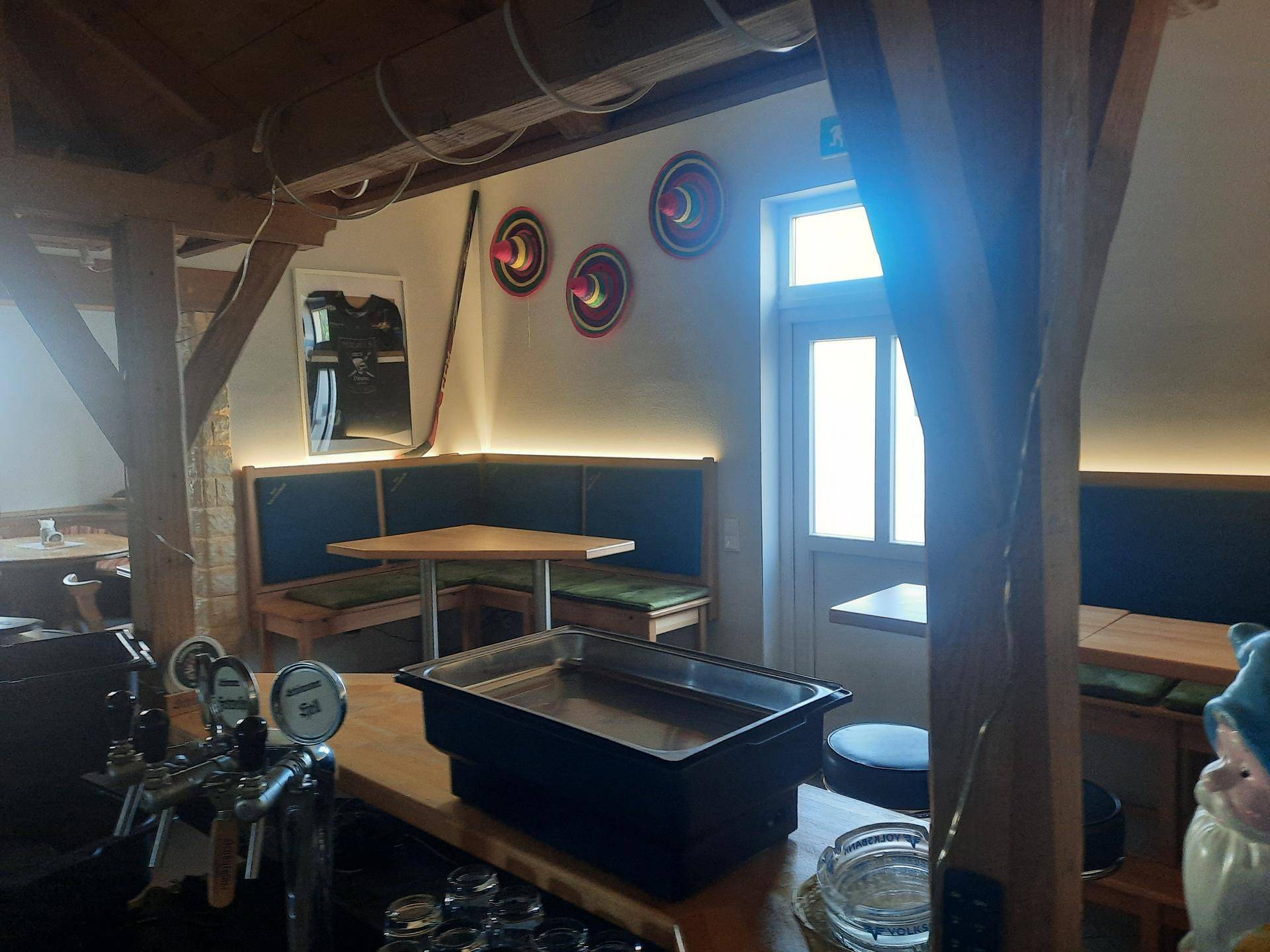 Rustikale Bar oder Gastraum mit Holzbalken, gemütlichen Sitzecken und indirekter Beleuchtung.