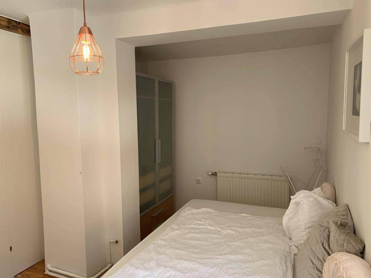 Gemütliches Schlafzimmer mit Bett, Kleiderschrank und Heizkörper.