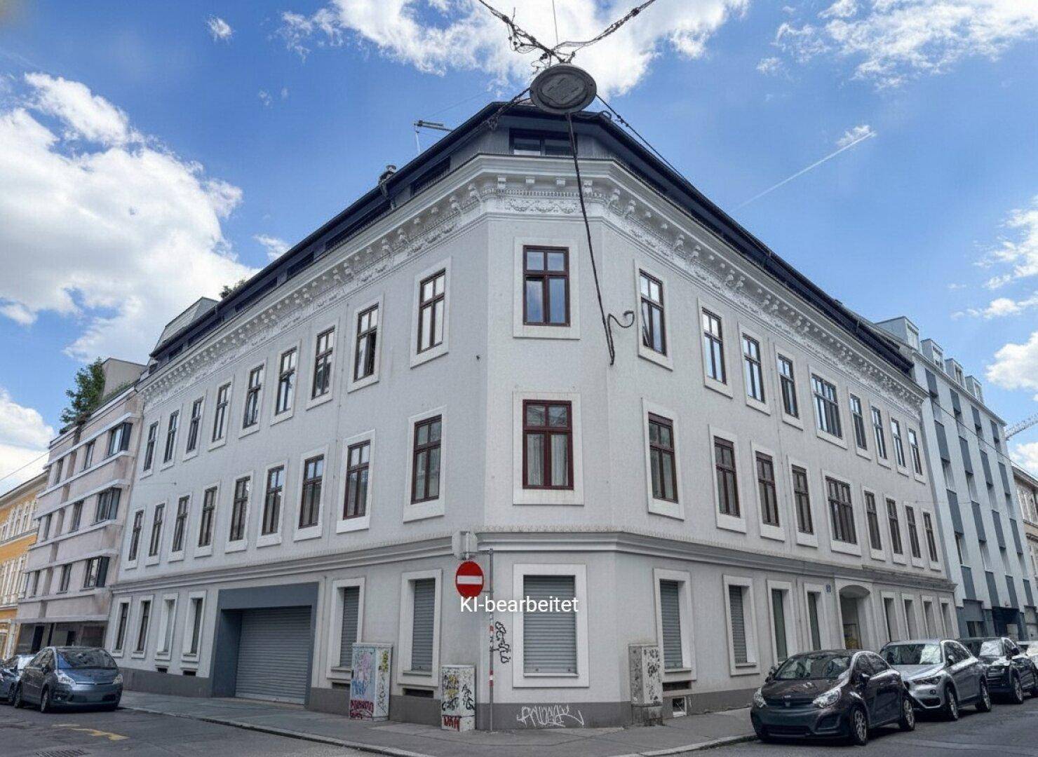 Eckgebäude mit klassischer Architektur und vielen Fenstern an einer städtischen Straße.