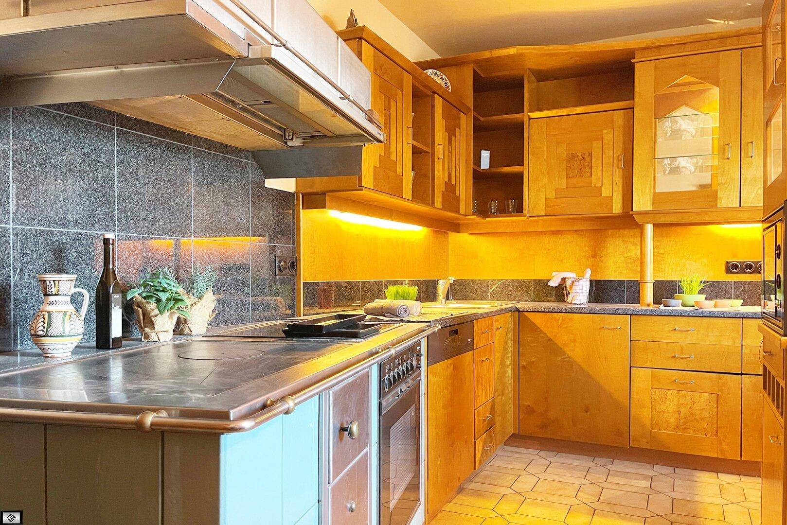 Traditionelle Holzküche mit blauen Akzenten, Fliesenrückwand und integrierten Geräten.