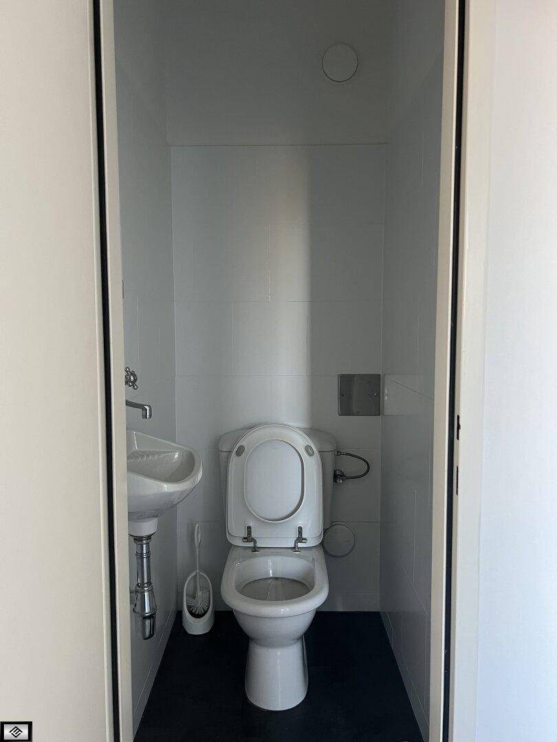 Kompaktes Gäste-WC mit Toilette und kleinem Handwaschbecken, funktional und sauber.