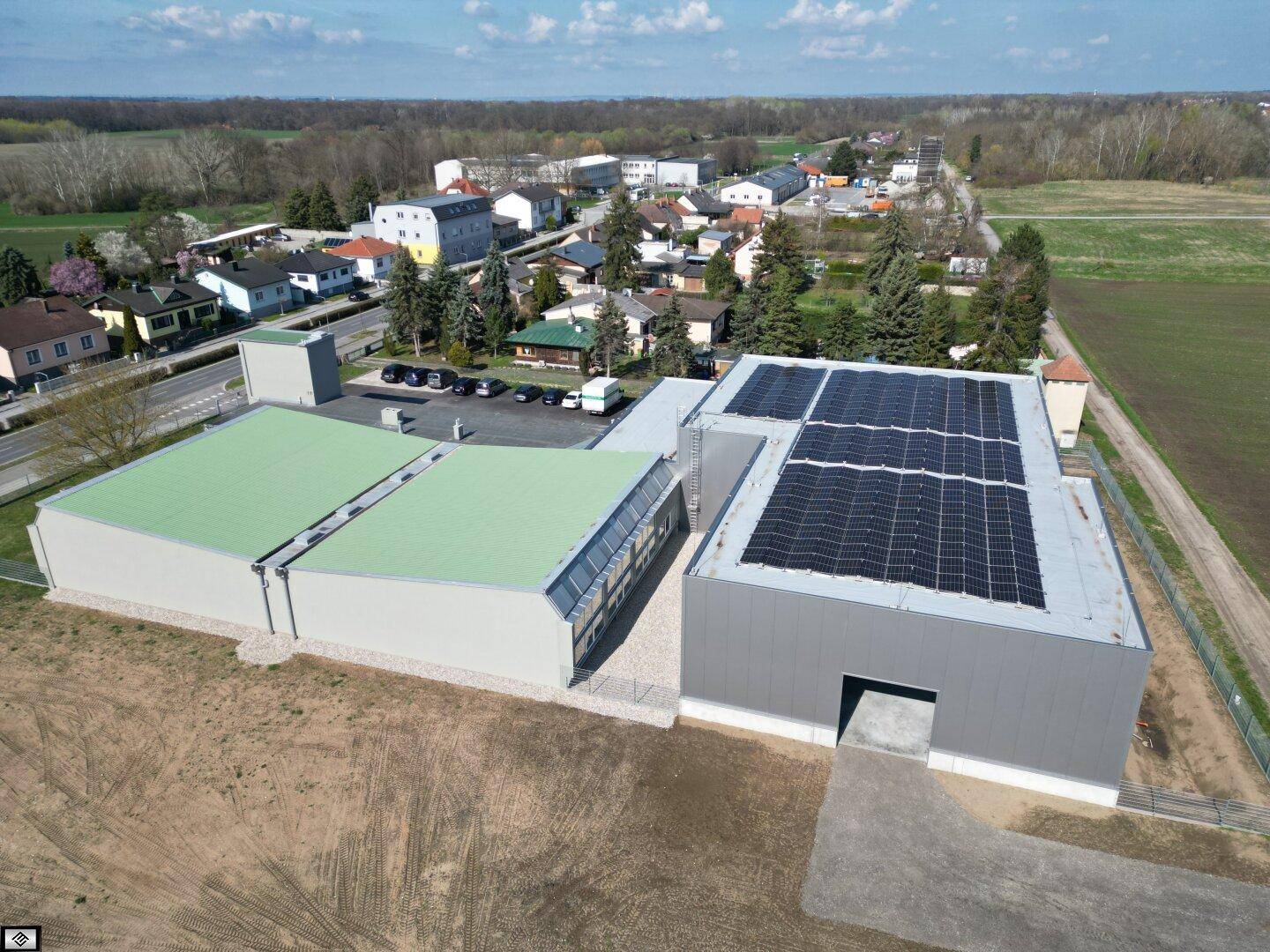 Übersicht aus der Luft des Industrieareals mit mehreren Hallen und Solarmodulen auf einem der Dächer.