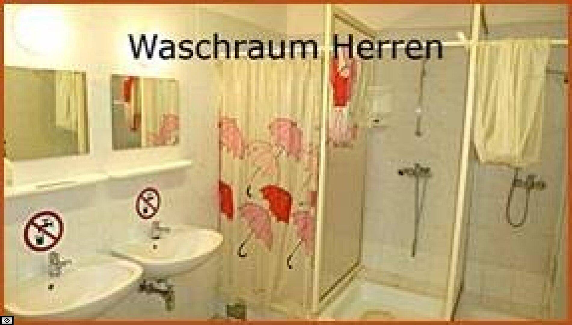 Herrenwaschraum mit zwei Waschbecken, Duschkabinen und Spiegeln, einfach und funktional eingerichtet.