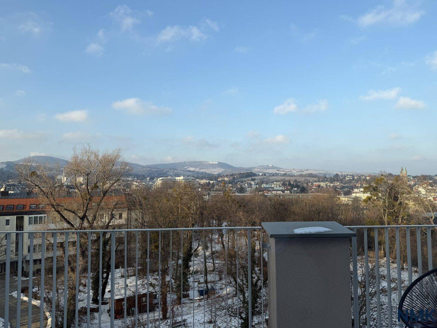 Weitläufige Terrasse mit Panoramablick über die verschneite Landschaft und die umliegenden Berge.