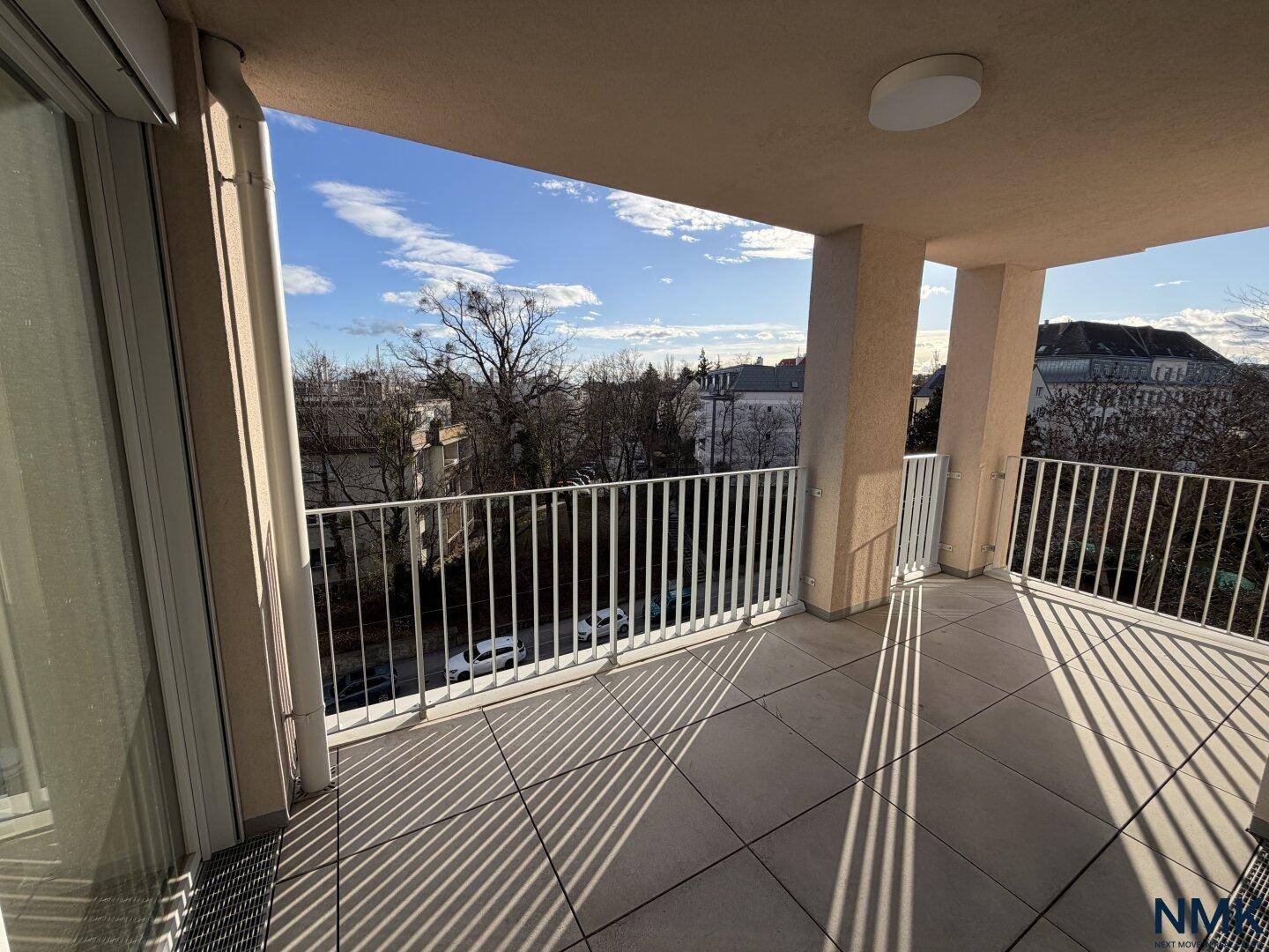 Geräumiger Balkon mit Fliesenboden und Metallgeländer, bietet einen weiten Blick über die Umgebung.