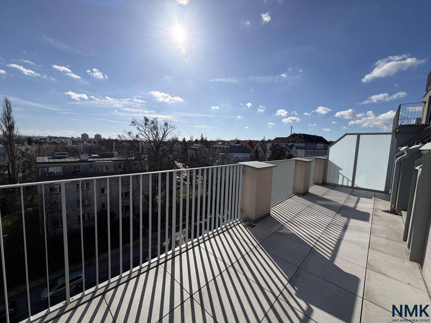 Große, sonnige Dachterrasse mit weitem Stadtblick und Metallgeländer.