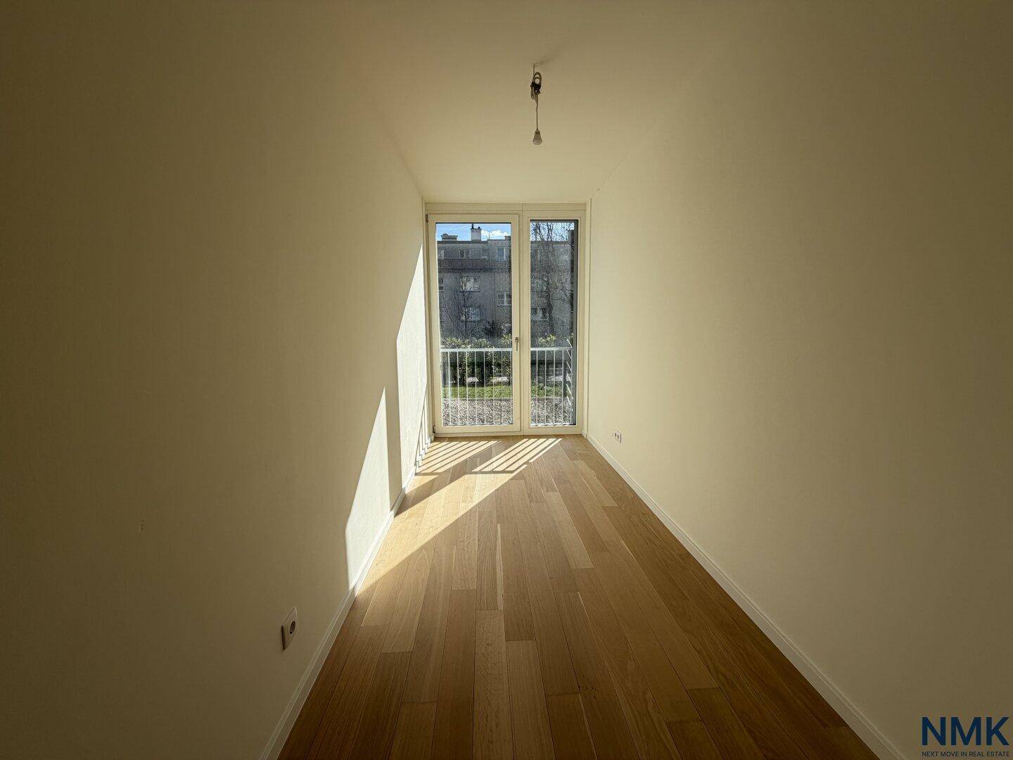 Langer, schmaler Raum mit Holzboden und Fensterfront, ideal als Flur oder kleines Zimmer.