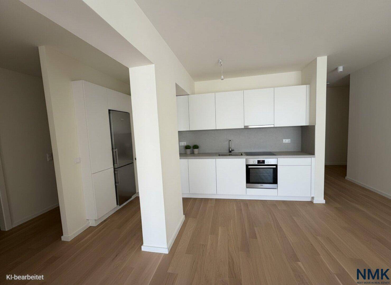Moderne, offene Küche mit weißen Schränken, integrierten Geräten und Holzboden.