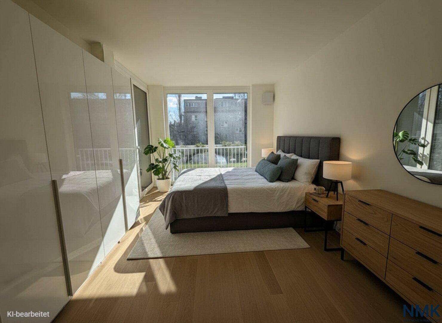 Modernes Schlafzimmer mit Doppelbett, weißen Schränken und Zugang zu einem französischen Balkon.