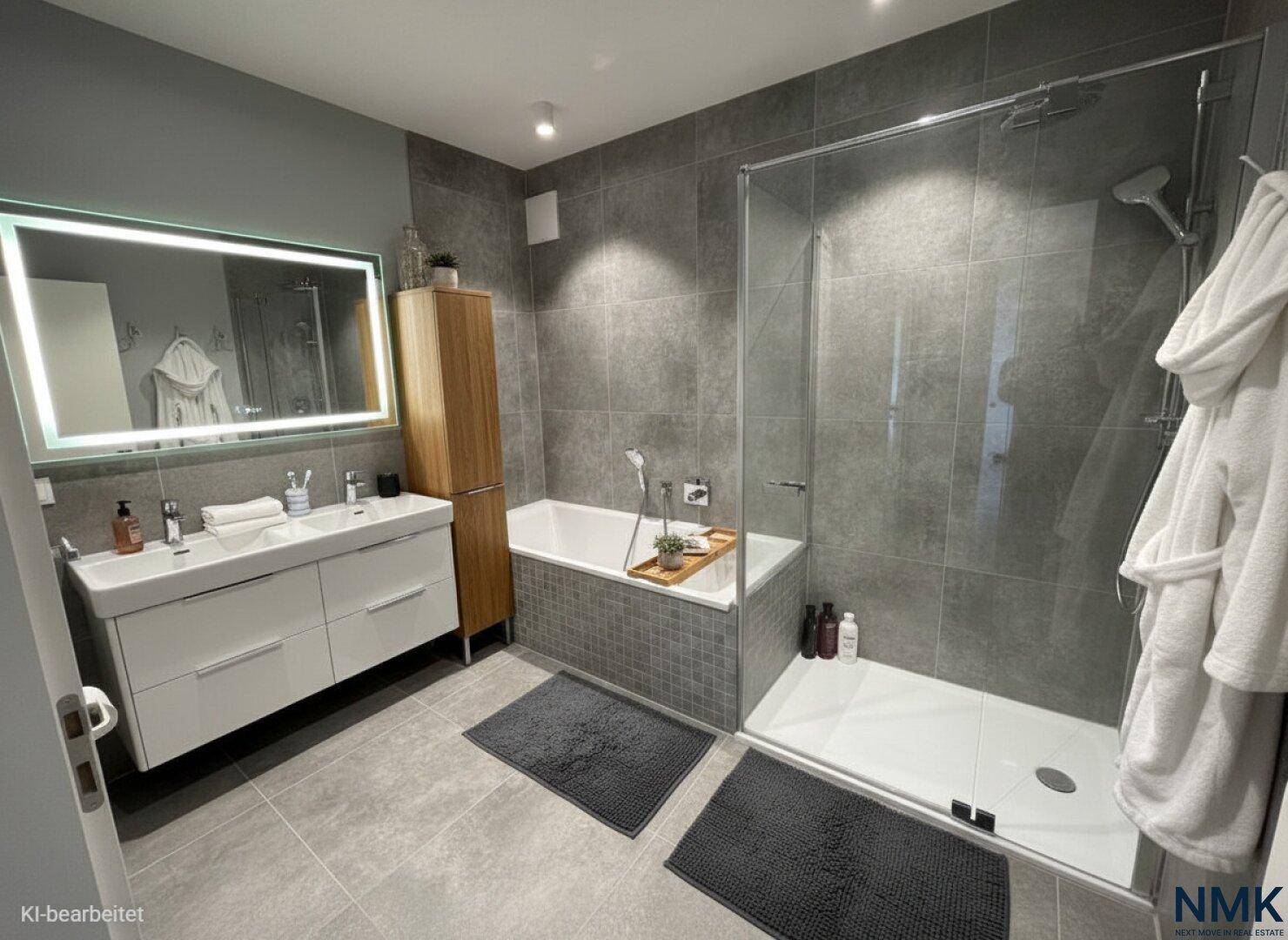 Modernes Badezimmer mit Doppelwaschbecken, beleuchtetem Spiegel, Badewanne und Dusche.