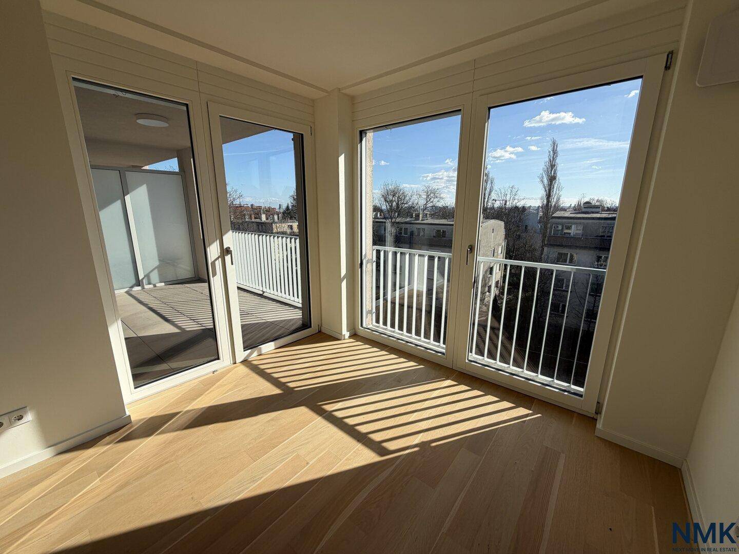 Eckzimmer mit viel Tageslicht und Zugang zu mehreren Balkonen.