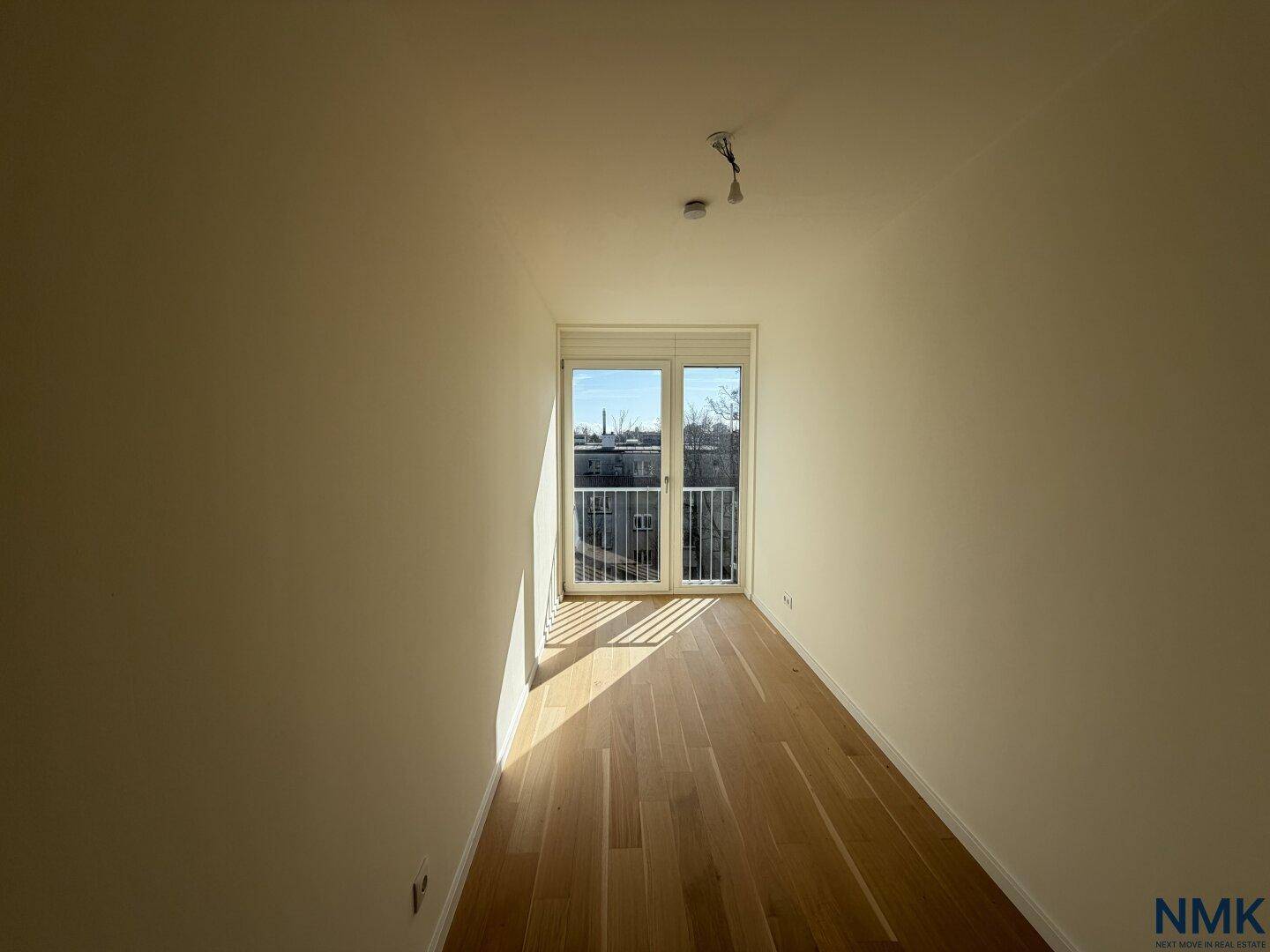 Kleines, helles Zimmer mit Holzboden und französischem Balkon, ideal als Büro.