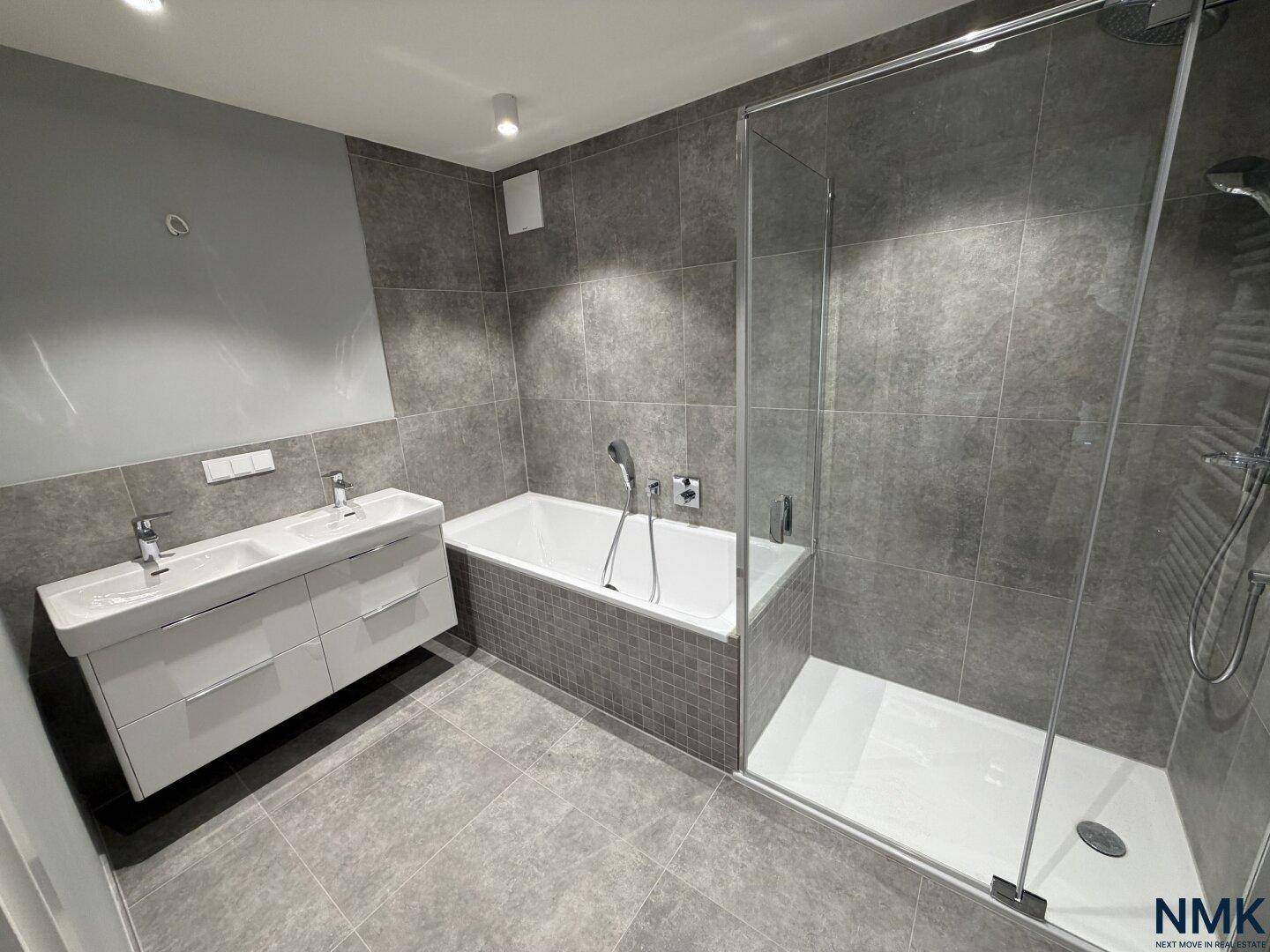 Modernes Badezimmer mit Doppelwaschbecken, Badewanne und geräumiger Duschkabine.