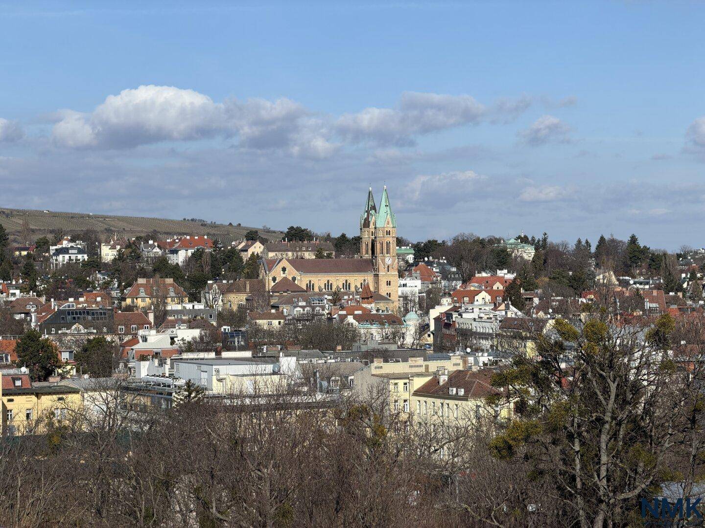Panoramablick über eine charmante Stadt mit Kirche und grünen Hügeln im Hintergrund.