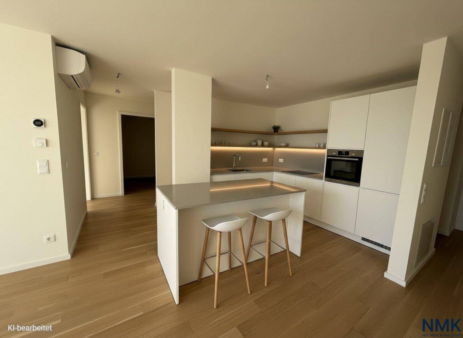 Moderne Einbauküche mit weißen Schränken, Kücheninsel und integrierten Geräten.