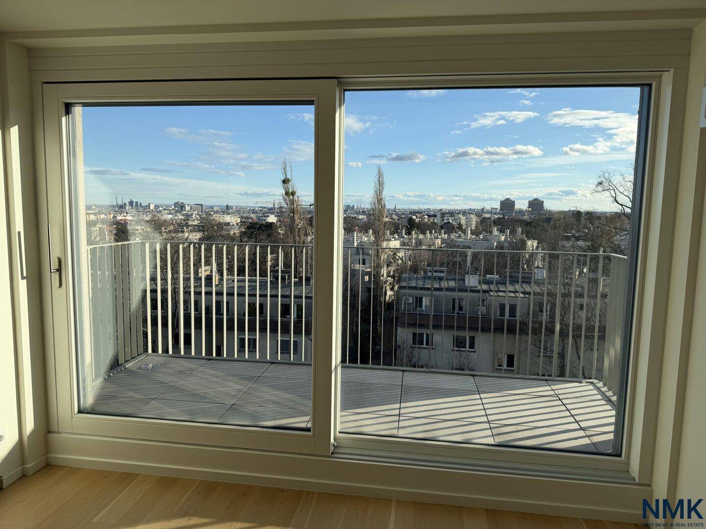 Große Schiebetüren führen auf einen Balkon mit weitem Blick über die Stadt.