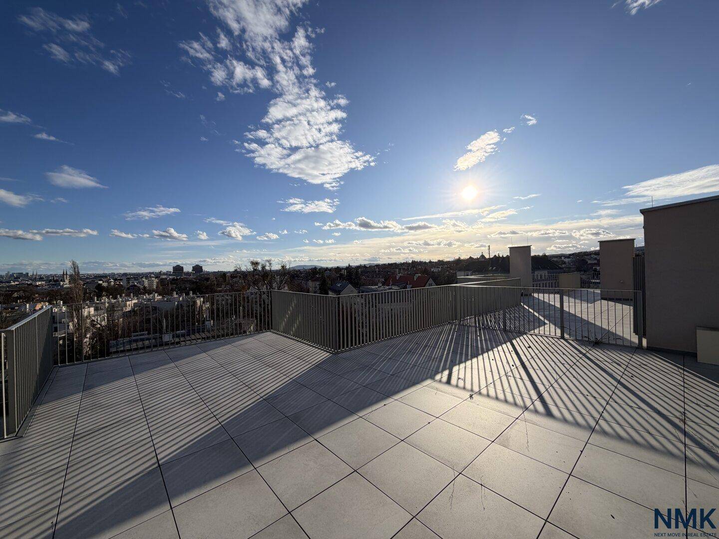 Sonnige, weitläufige Dachterrasse mit Panoramablick über die Stadt und den Horizont.