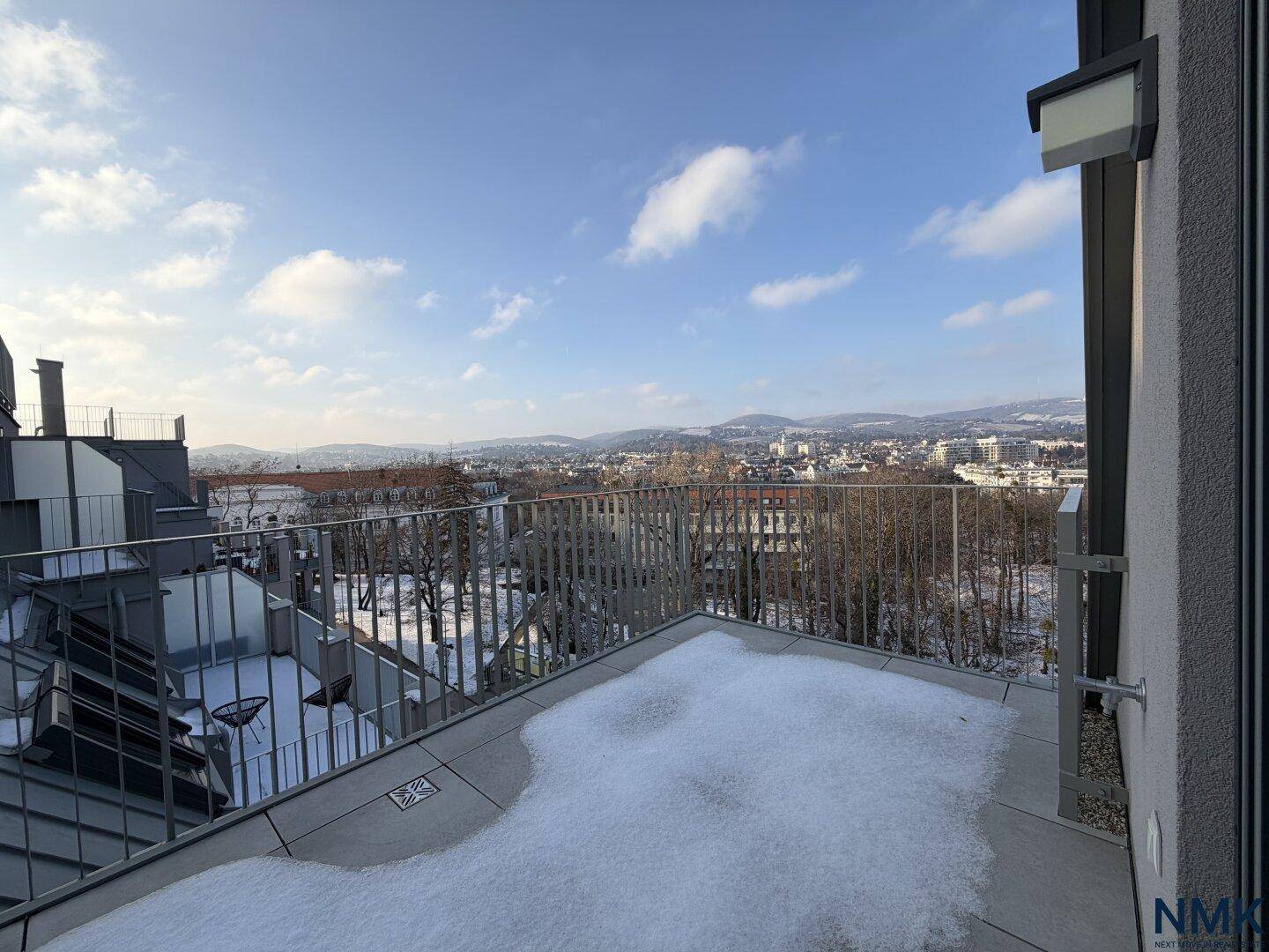 Große Dachterrasse mit Schnee und Panoramablick über die Stadt und die Umgebung.