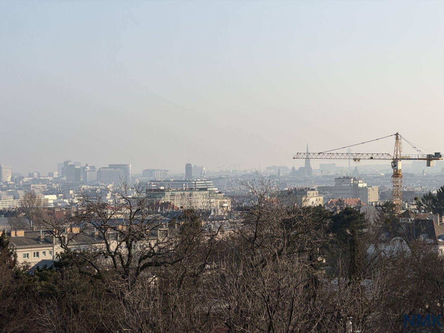 Weitläufiger Blick über die Stadt mit Kränen und Gebäuden unter klarem Himmel.