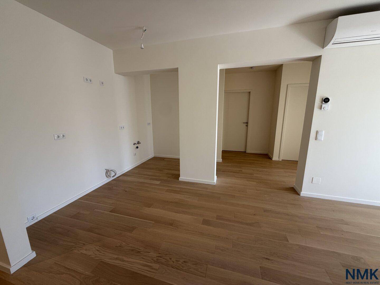 Heller Raum mit Holzboden und vorbereiteten Anschlüssen, ideal für individuelle Gestaltung.