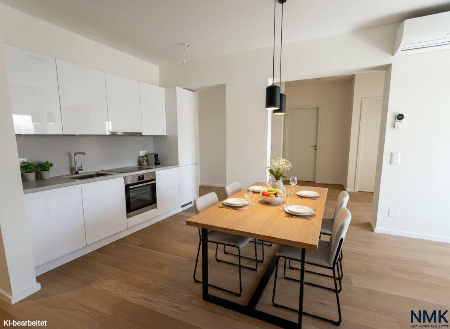 Moderne Einbauküche mit weißen Fronten, integriertem Essbereich und Holzboden.