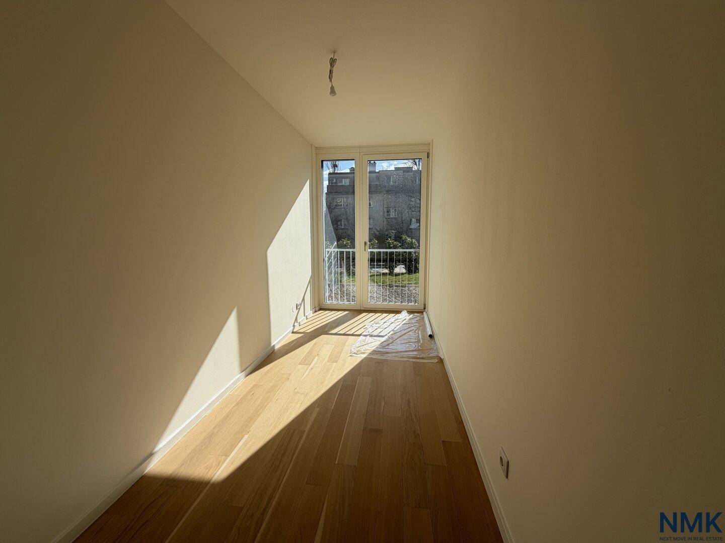 Helles Zimmer mit Holzboden und großen Fenstern, ideal als Büro oder Gästezimmer nutzbar.