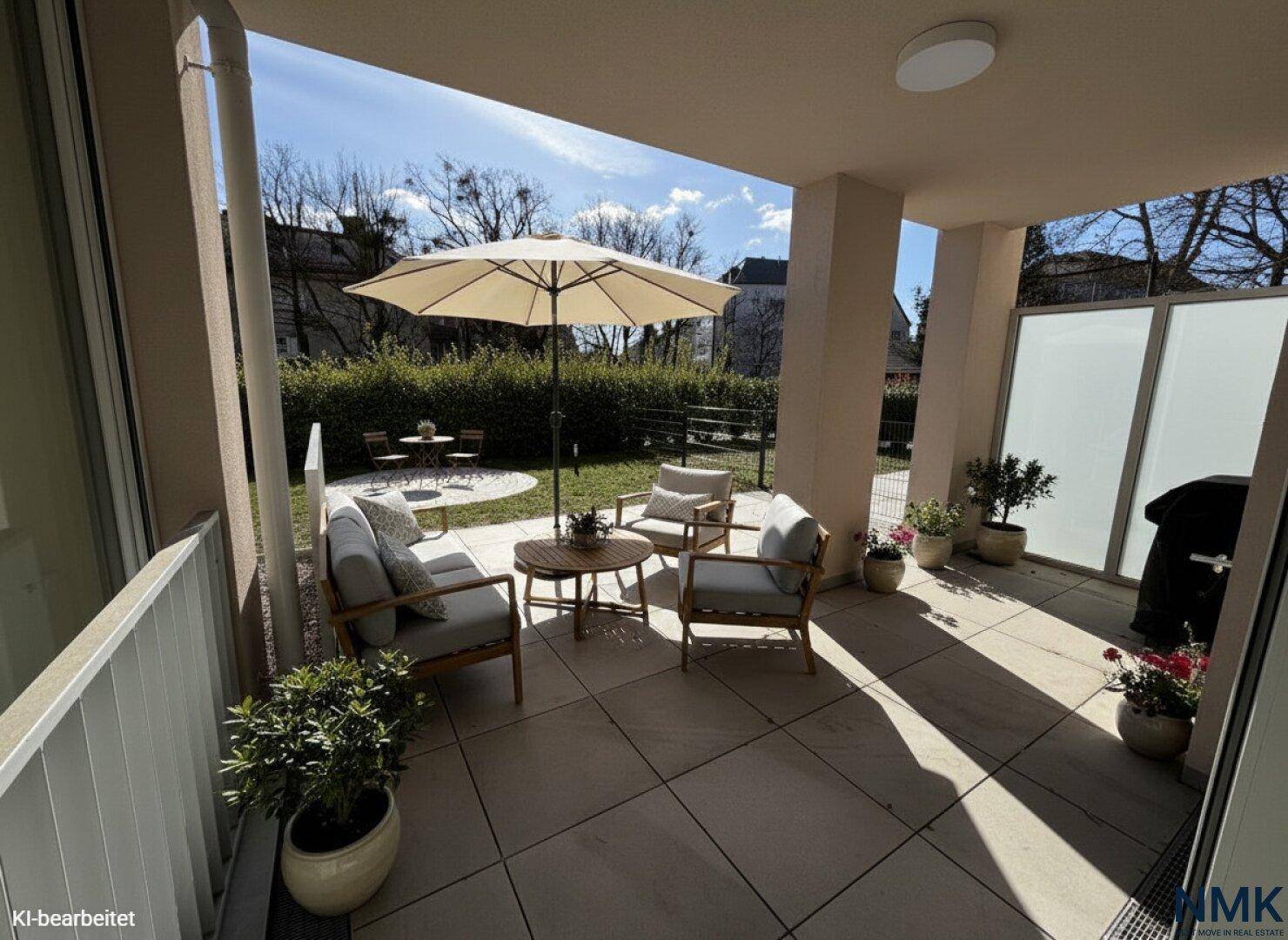 Möblierte Terrasse mit Sonnenschirm, Sitzgelegenheiten und Pflanzen, ideal zum Entspannen im Freien.