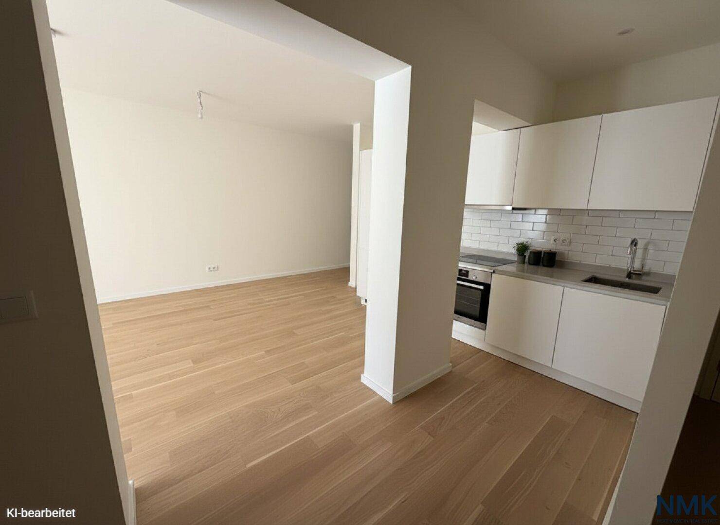 Moderne Einbauküche mit weißen Schränken, integrierten Geräten und hellem Holzboden.