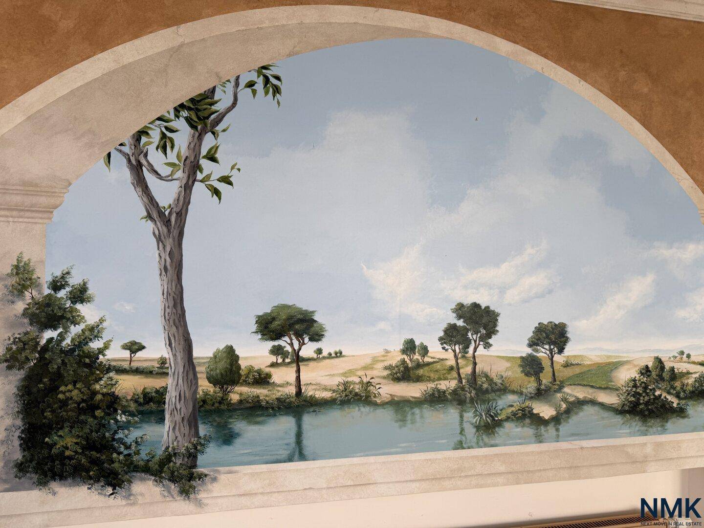 Detailansicht der Wandmalerei im Poolraum, die eine idyllische Landschaft mit See und Bäumen darstellt.
