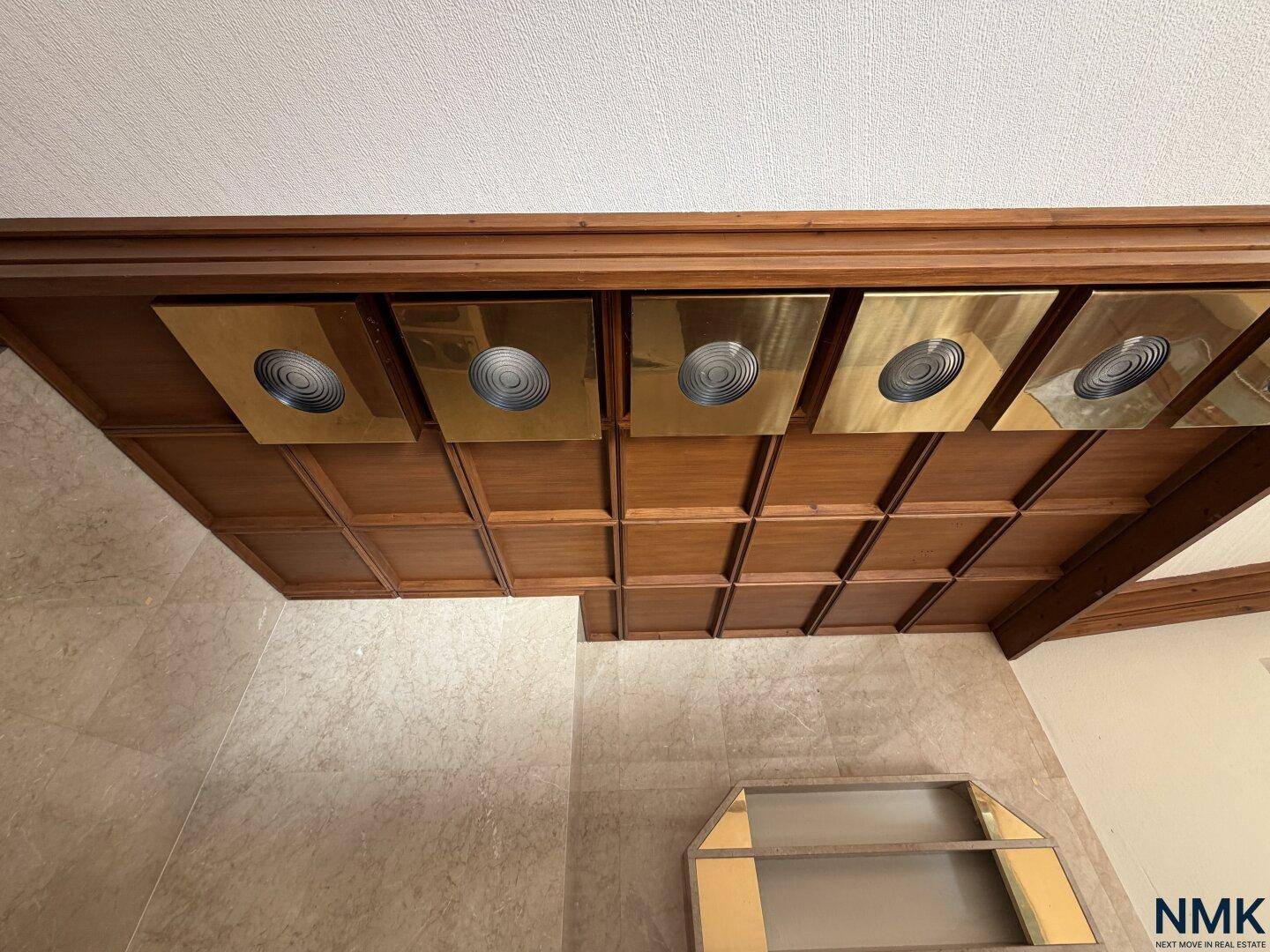 Detailaufnahme der kunstvollen Holzdeckenverkleidung über dem Barbereich mit integrierten Leuchten.