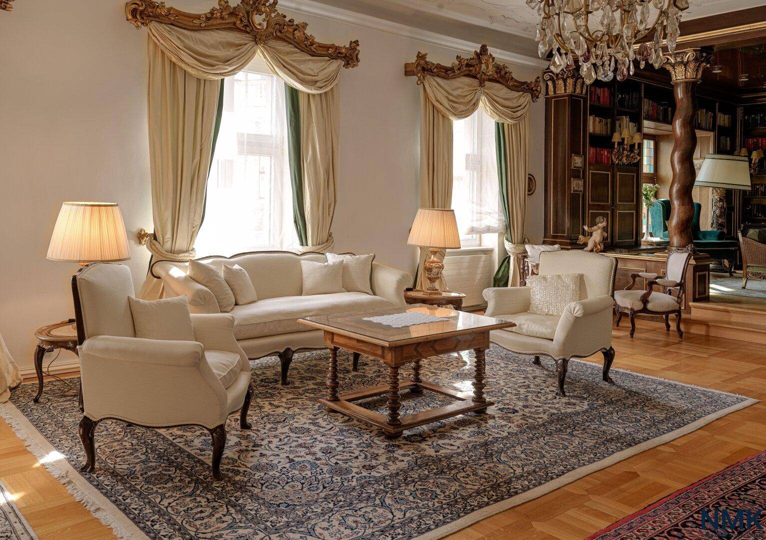 Helles Wohnzimmer mit eleganten Vorhängen, Stuckdecken und klassischem Mobiliar.
