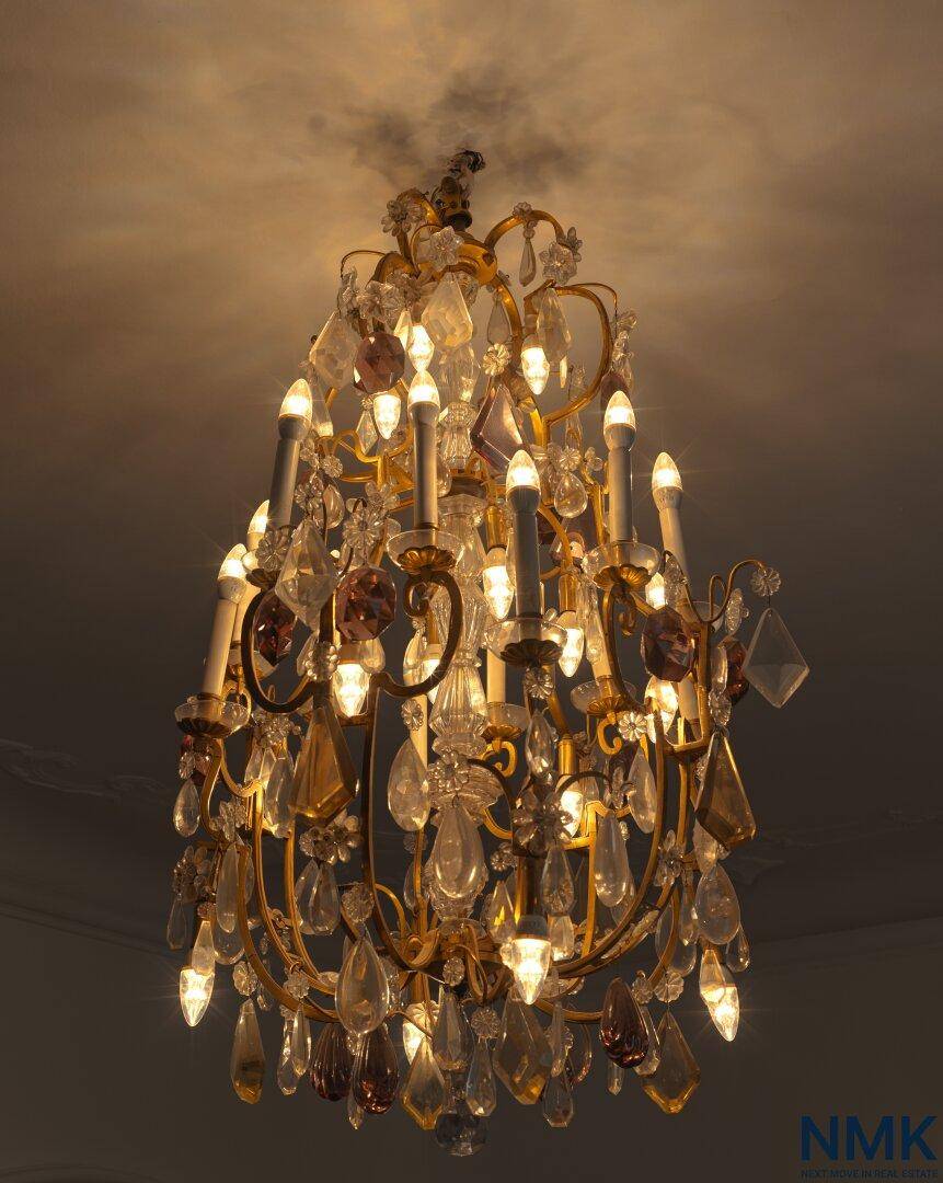 Prunkvoller Kronleuchter mit vielen Kristallen und Kerzenlampen, der Eleganz ausstrahlt.