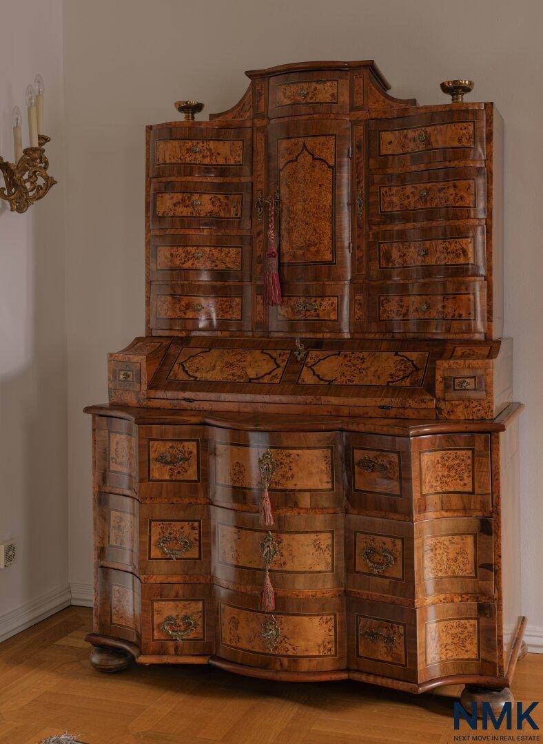 Antiker Sekretär aus Holz mit aufwendigen Intarsien und geschwungenen Formen.