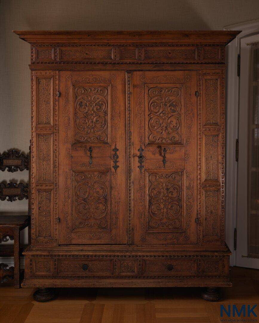 Großer antiker Holzschrank mit kunstvollen Schnitzereien und traditionellem Design.