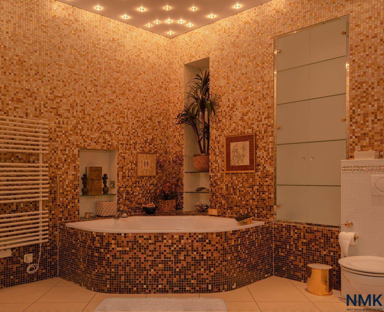 Luxuriöses Badezimmer mit Eckbadewanne, Mosaikfliesen und Einbaustrahlern.
