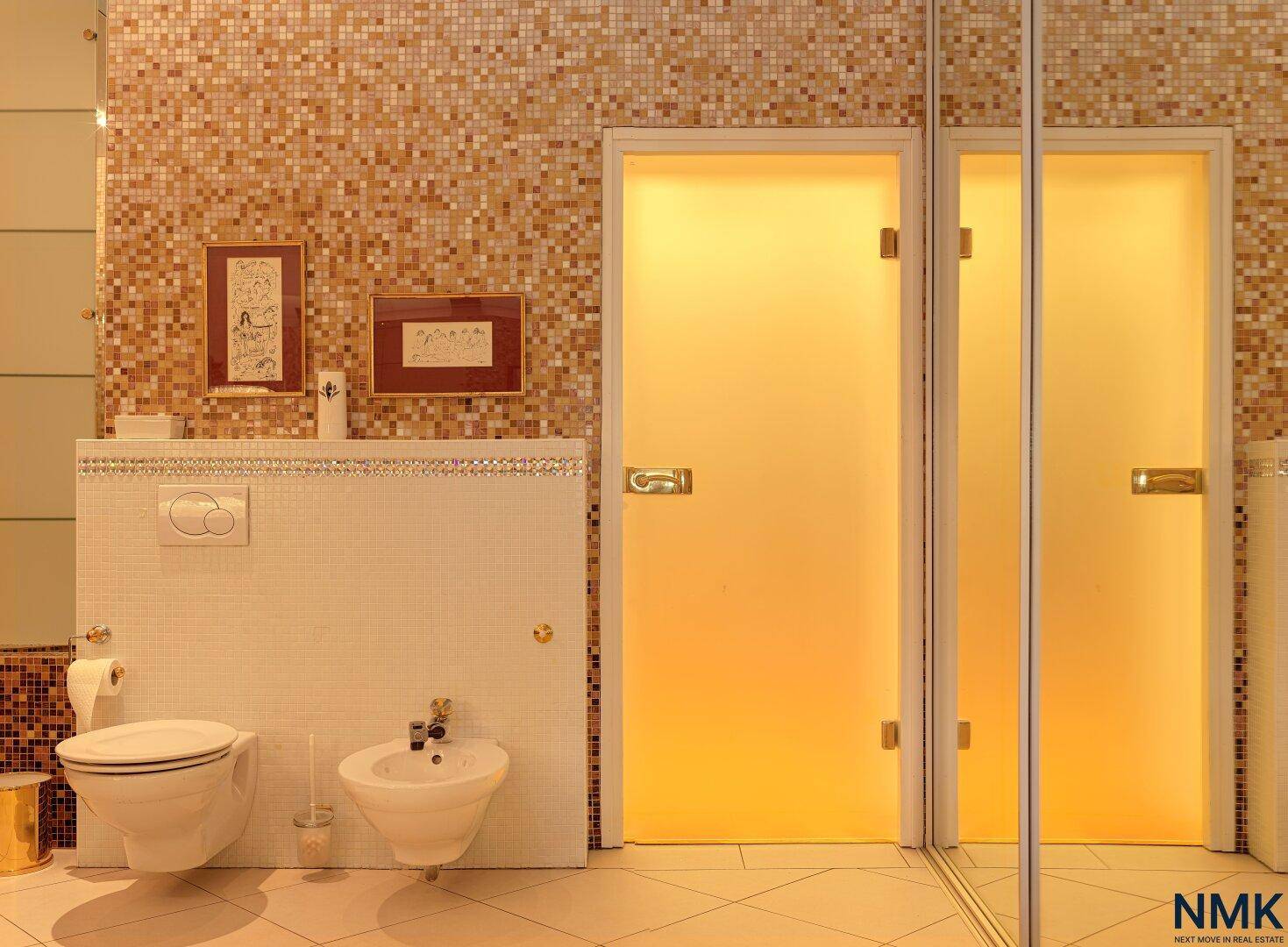 Elegantes Badezimmer mit Bidet, Toilette und Mosaikfliesen in warmen Farbtönen.