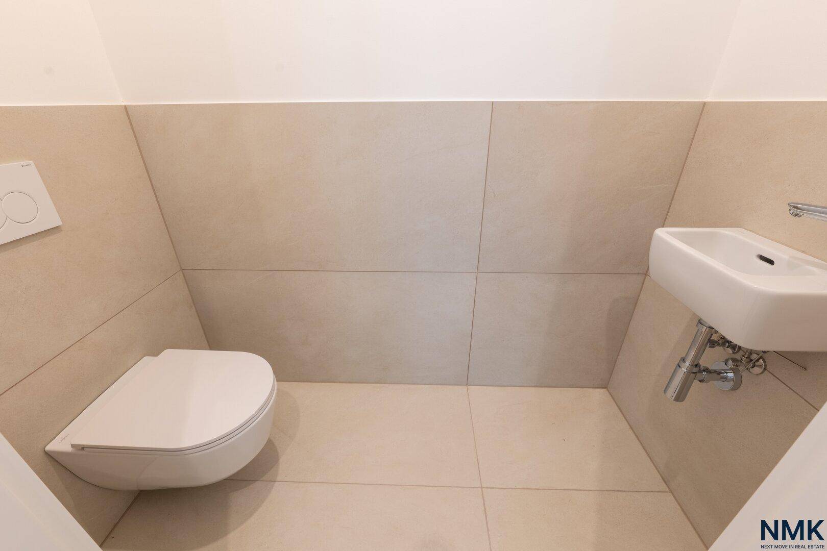 Modernes Gäste-WC mit wandhängender Toilette und kleinem Waschbecken.