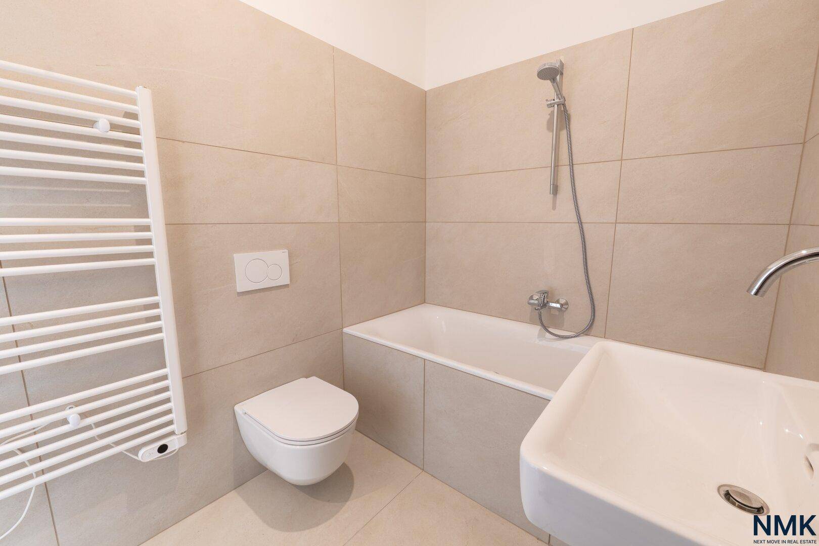 Modernes Badezimmer mit Badewanne, Dusche, wandhängender Toilette und Handtuchheizkörper.