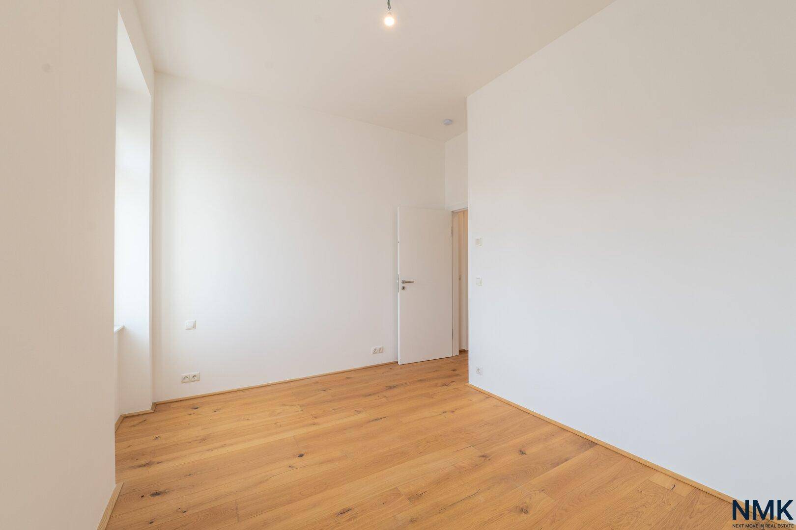 Ruhiges Zimmer mit Holzboden und einem Fenster, geeignet als Kinder- oder Gästezimmer.